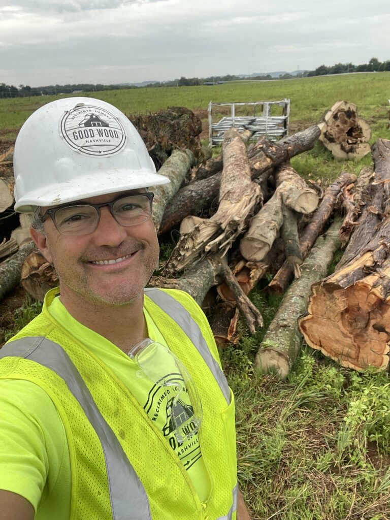 Good Wood owner Dave Puncochar standing in front of pile of downed trees